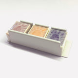 White coloured metal watercolour half pan holder containing three wrapped watercolour half pans.